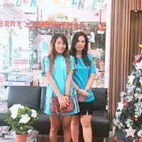 Two people posing beside the clinic window