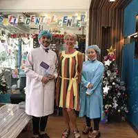Three people outside the clinic in festive costumes