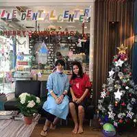 Two people outside Smile Dental Center beside festive decorations