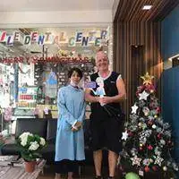 Two people posing outside the dental clinic entrance