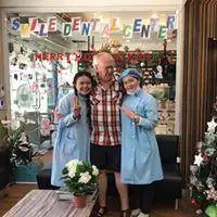 Three people posing outside Smile Dental Center